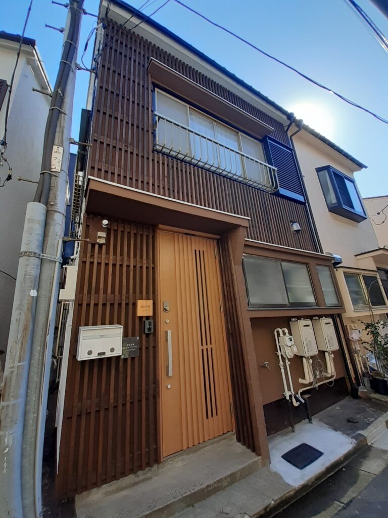 木製格子と縦張りの外壁に改修した住宅の外観